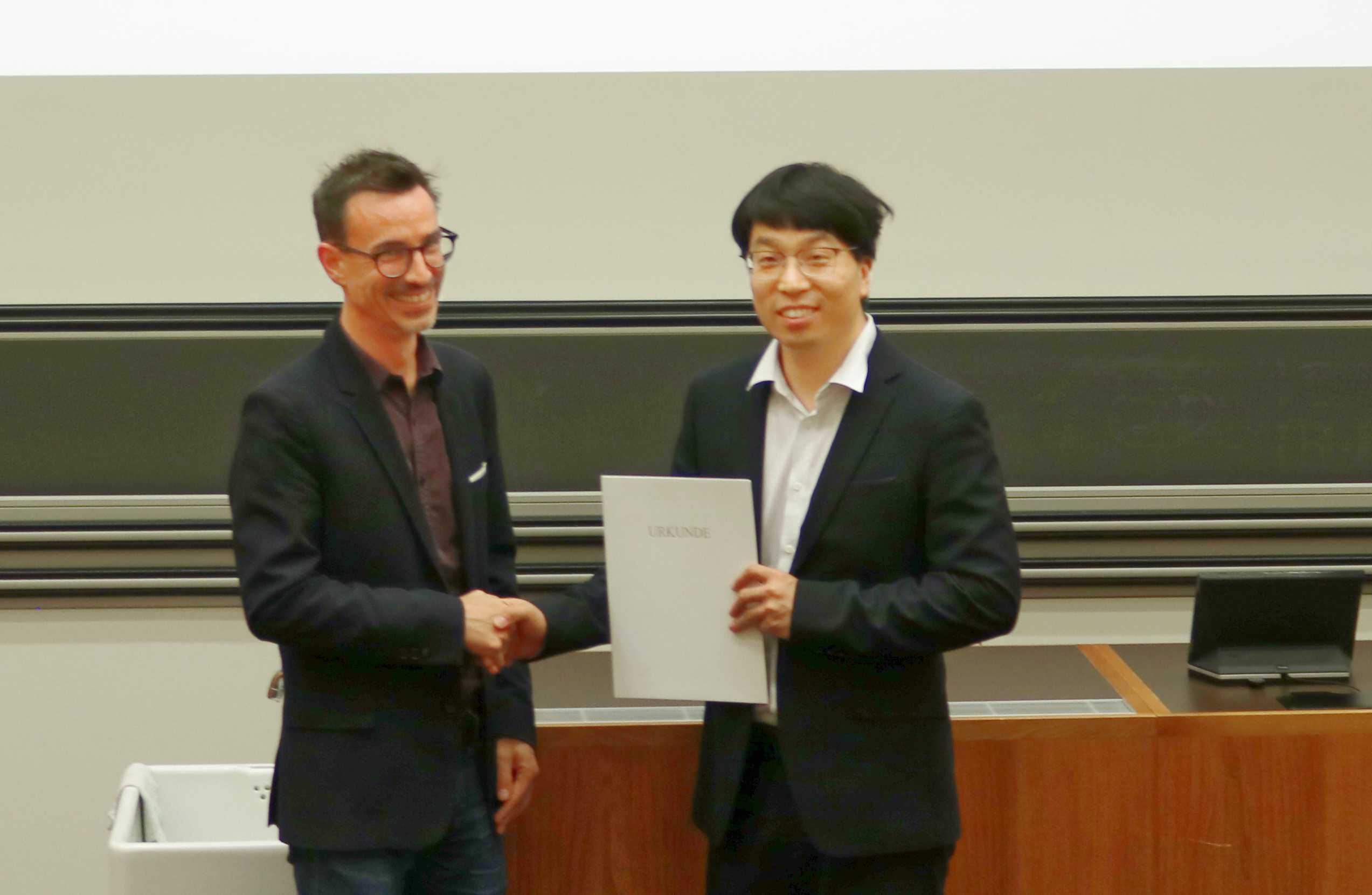 Prof. Guillaume Habert (IBI Lehrstuhl für Nachhaltiges Bauen) überreicht den diesjährigen BI-​Förderungspreis 2023 an Dr. Yi Du.  